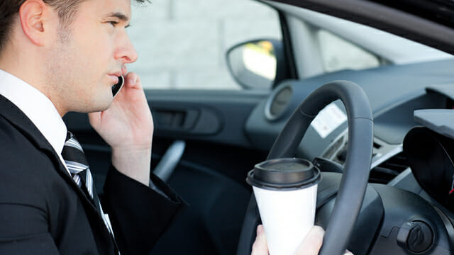 Distracted Driver Talking on the Phone While Drinking Coffee